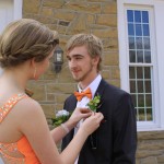 Stephanie putting on Marcus' Boutineer