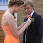 Stephanie putting on Marcus' Boutineer